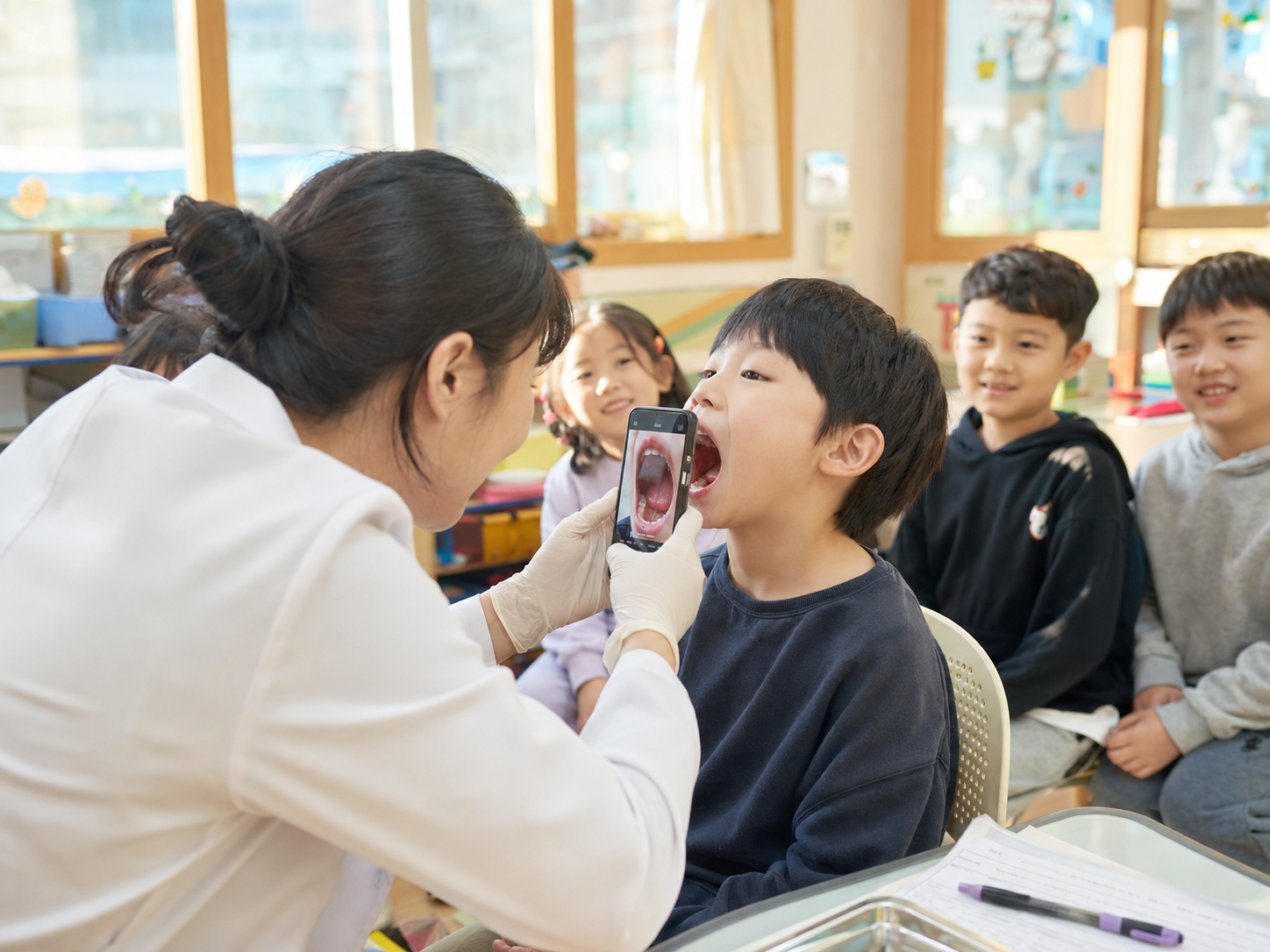 교실에서 스마트폰으로 학생의 구강을 촬영하는 검사 현장